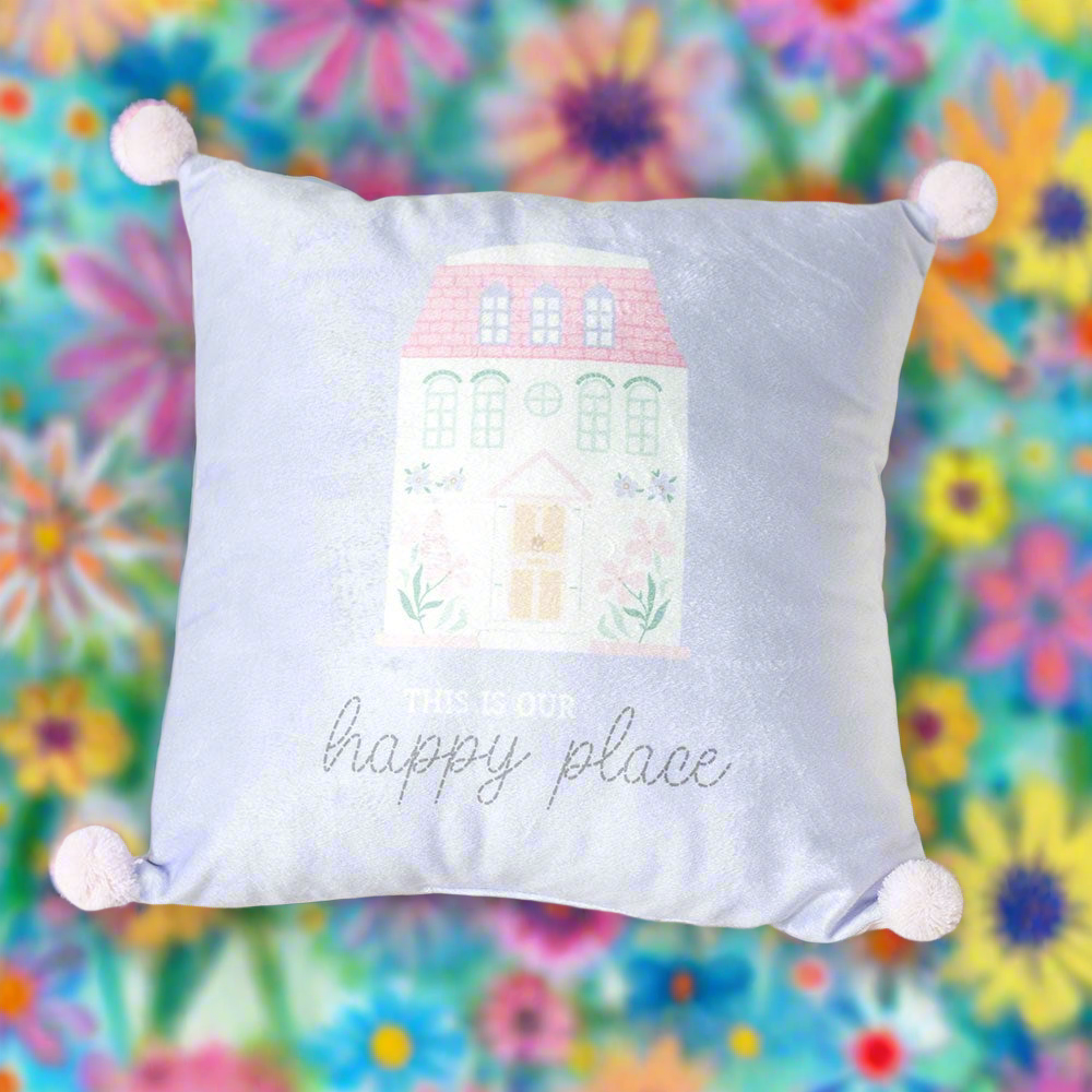 35cm Square cushion in pastel blue and pink featuring a charming house illustration and the phrase 'This Is Our Happy Place' with playful pom pom details.