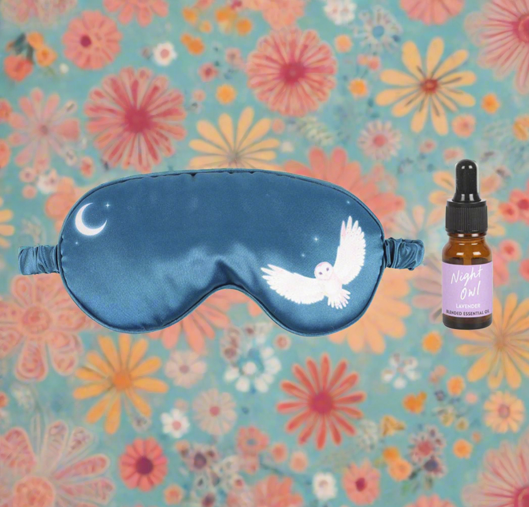 Charming Night Owl Sleep Mask and Essential Oil Gift Set featuring a navy-blue satin sleep mask with a mystical owl design and a 10ml bottle of lavender essential oil for promoting restful sleep and calming stress.