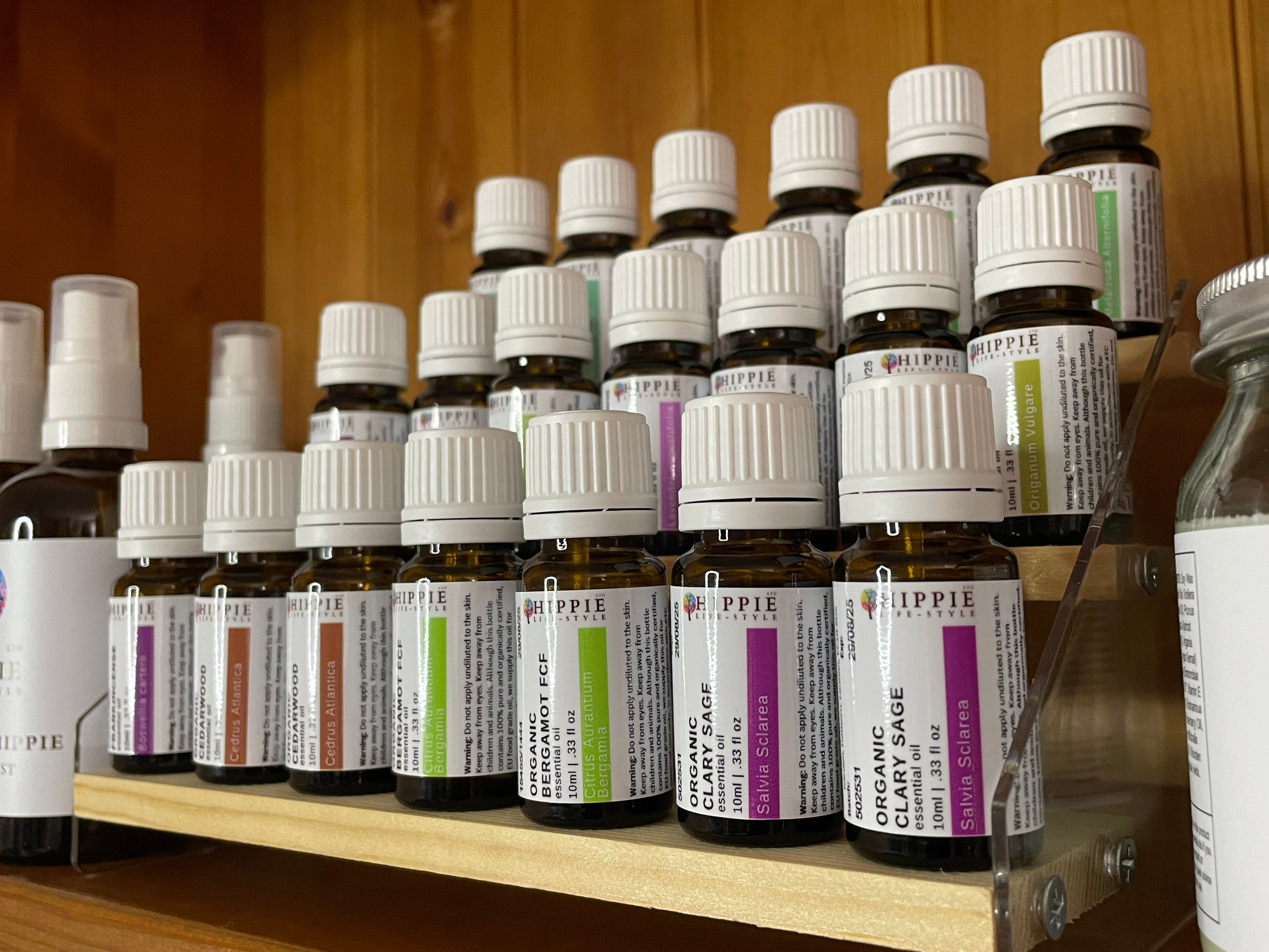 Organic and pure essential oils UK from HIPPIE, standing in three rows in a professional quality image in a therapeutic aromatherapist office.